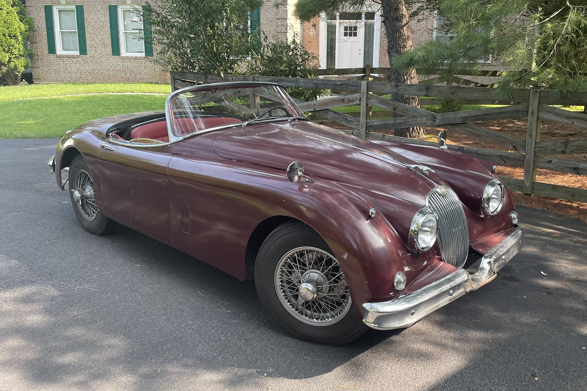 1959 Jaguar XK150 Roadster, maroon, top down. open two seater