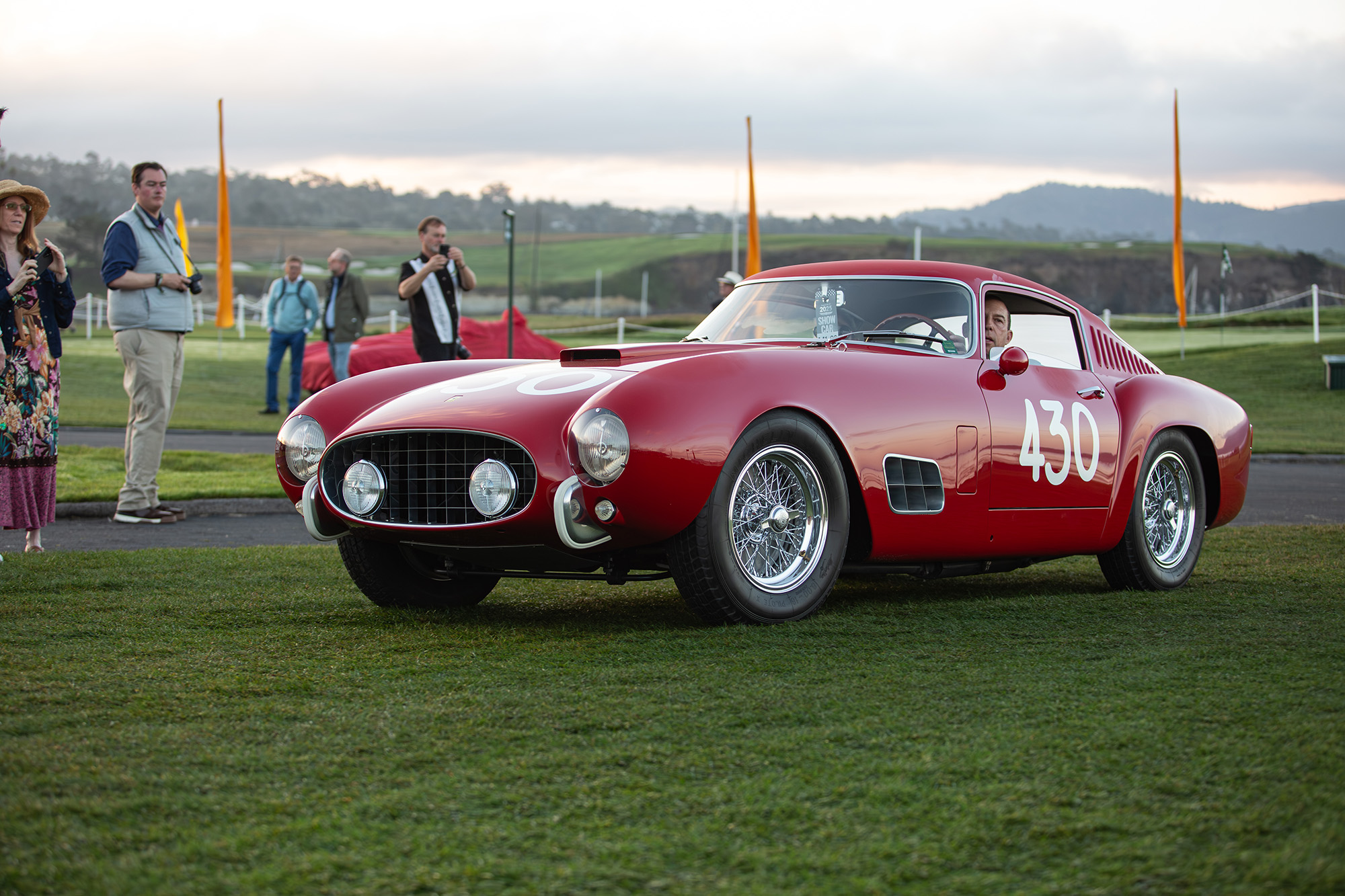 1957 Ferrari 250 GT Tour de France, front quarter, car driving on the grass at Pebble Beach Concours
