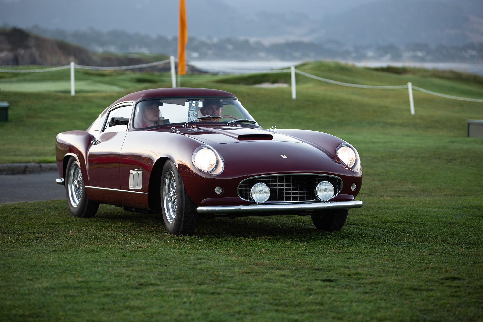 1958 Ferrari 250 GT Tour de France, front quarter, dark red, on grass at Pebble Beach