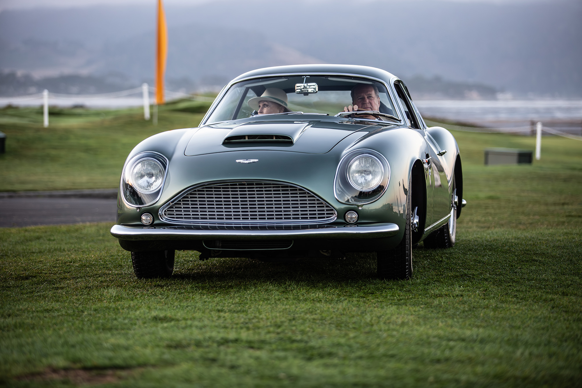 1961 Aston Martin DB4GT Zagato, front view, driving on the grass at Pebble Beach concours