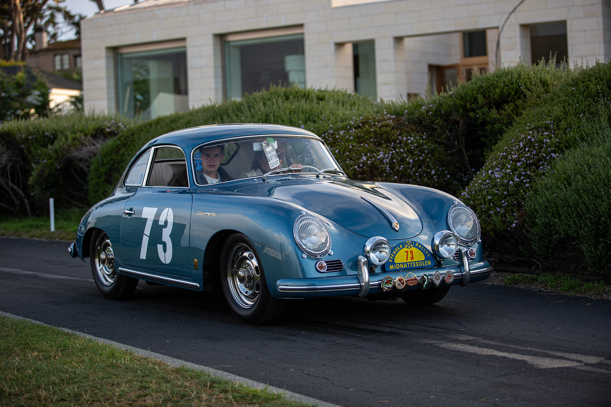 1956 Porsche 356 Carrera 1500GS Coupe, front quarter, car driving on paved path about to enter the Pebble Beach show field