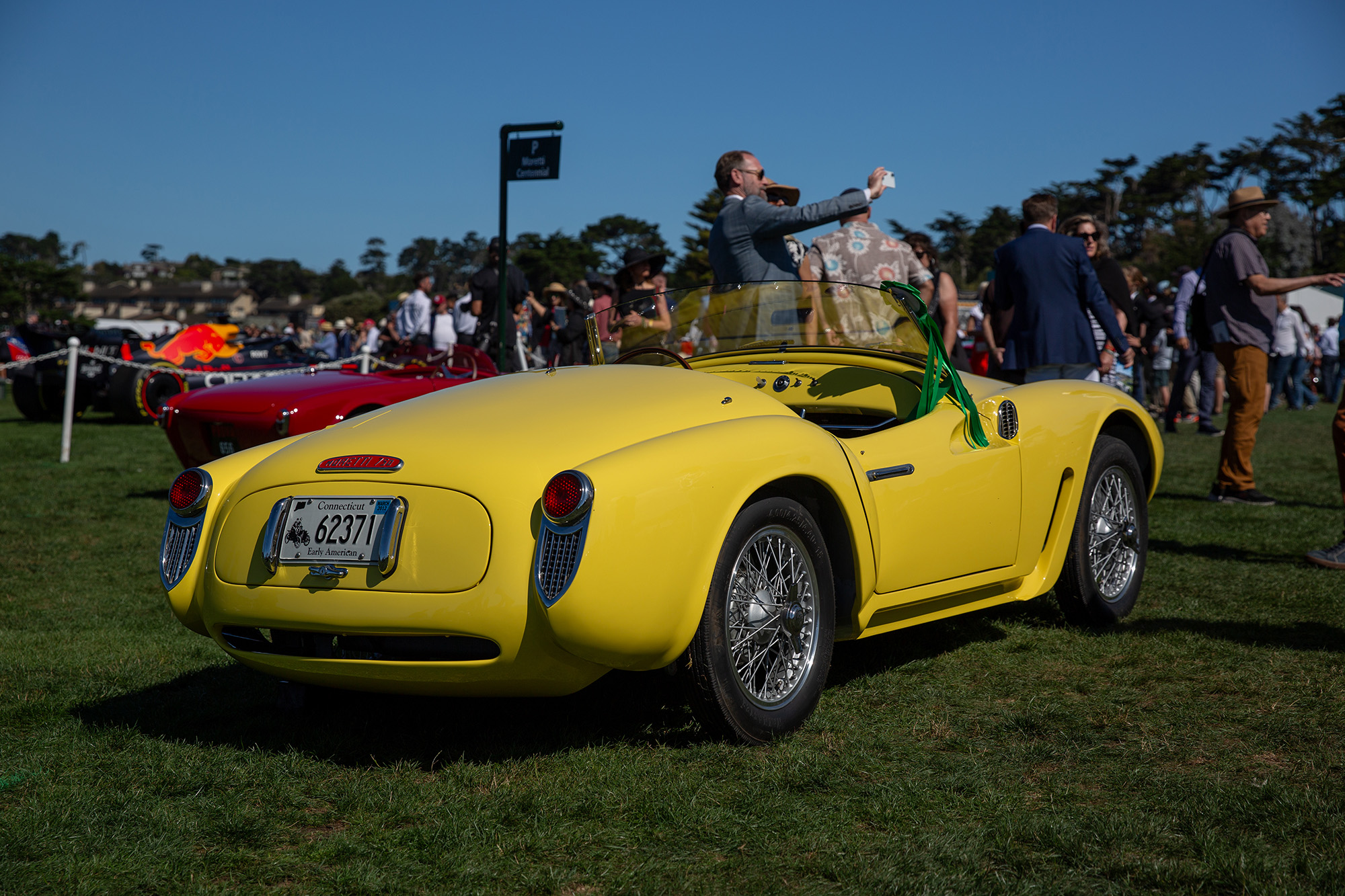 1955 Moretti 750 Gran Sport Mota Spyder, yellow, rear quarter view, on the grass at Pebble Beach